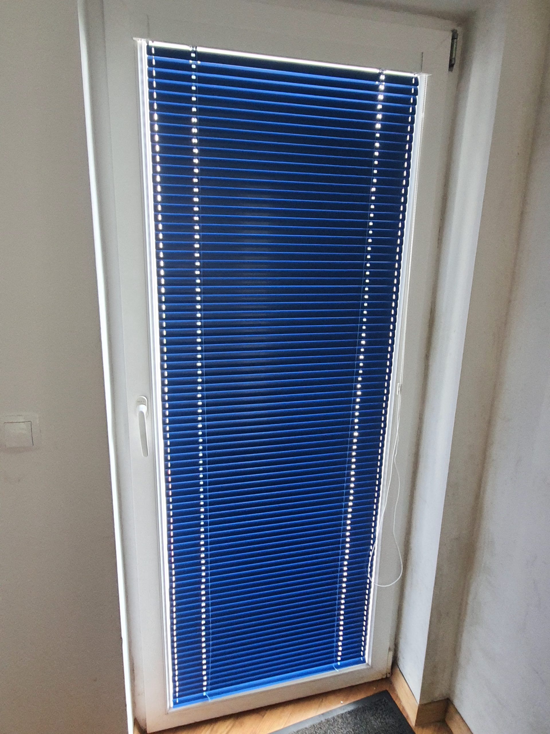 Notranje žaluzije ISOLINE v modri barvi montirane na okno v Zambratiji leta 2025.